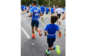 Corre trascinando un bambino legato con una corda durante una maratona! Scoppia il caos